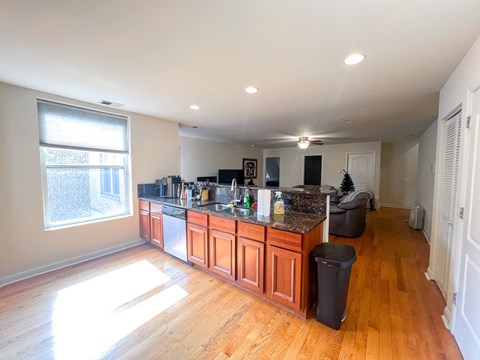 A kitchen with wooden cabinets and a large window.