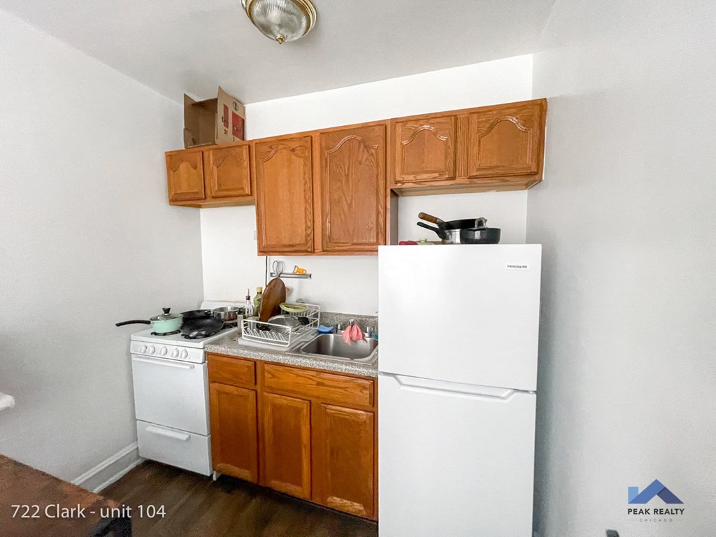 a small kitchen with white appliances and wooden cabinets