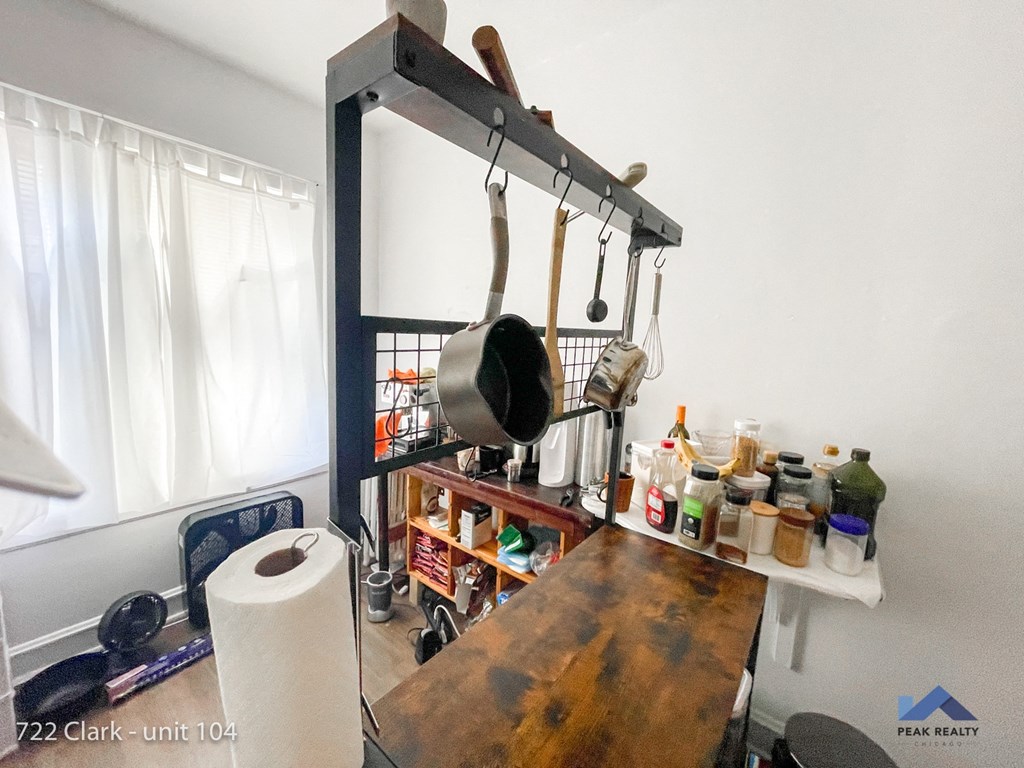 a small kitchen with a wooden counter top and a metal rack with pots and pans