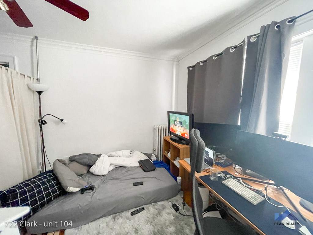a bedroom with a bed and a desk with a computer