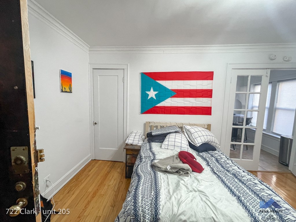 a bedroom with a bed and a flag on the wall