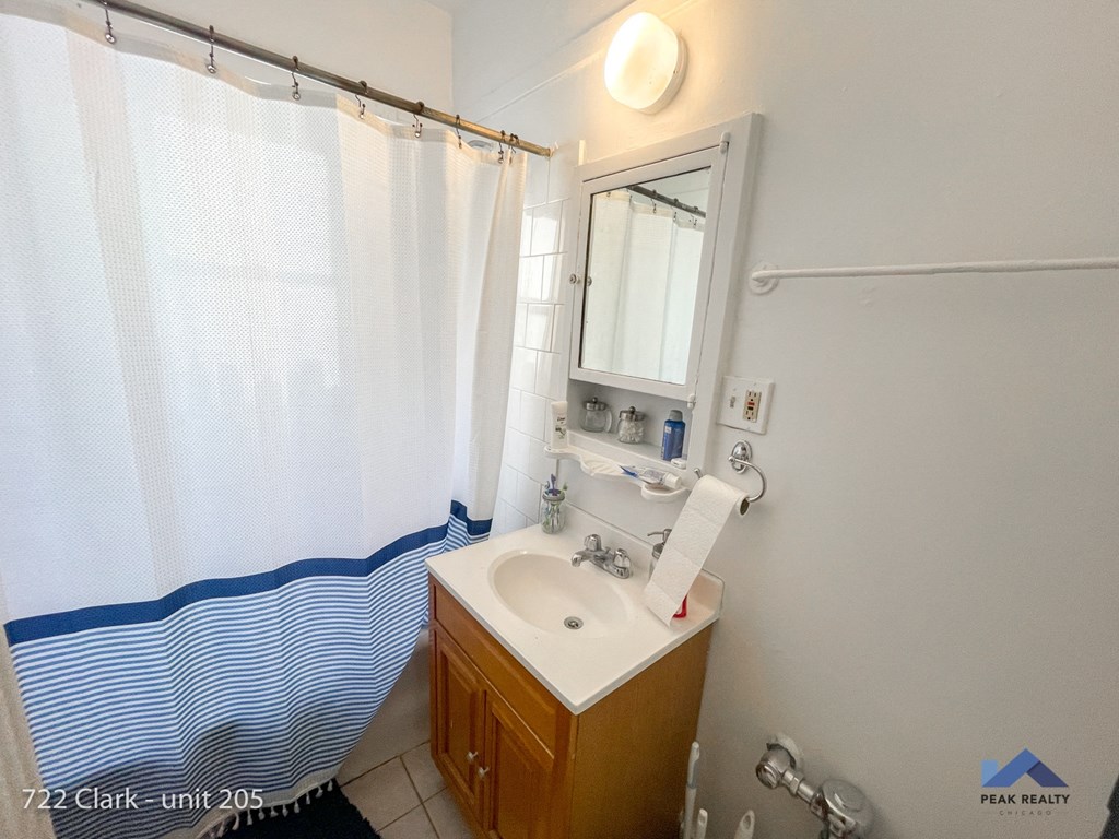 a bathroom with a shower and a sink and a shower curtain