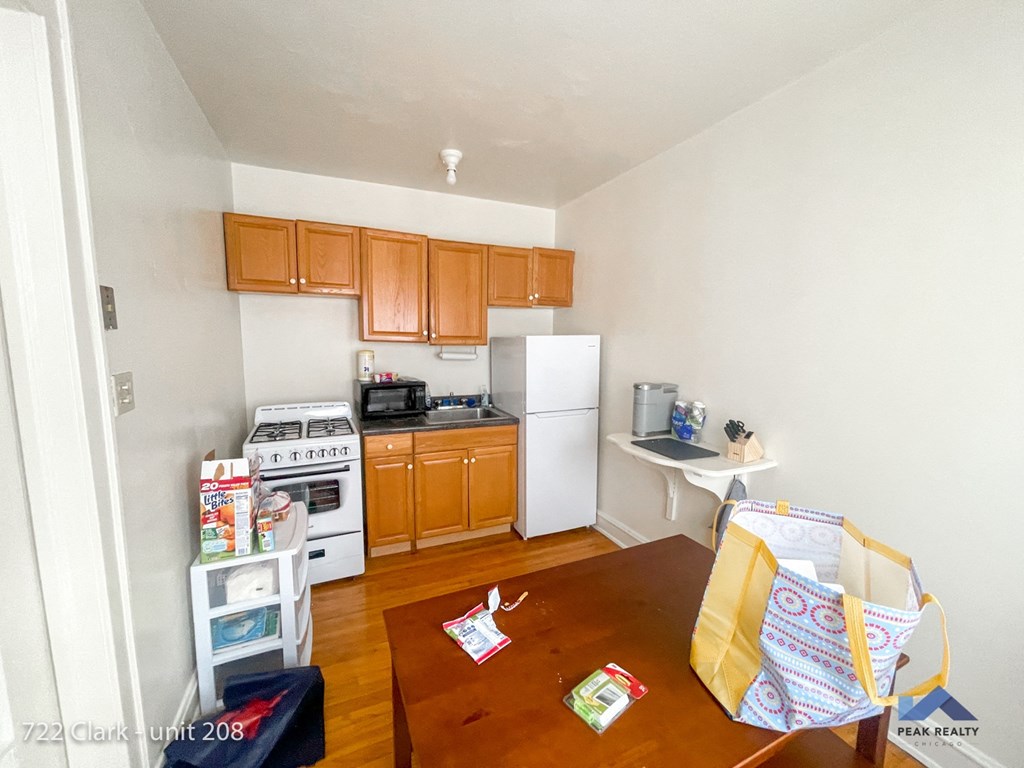 a small kitchen with wooden floors and white appliances