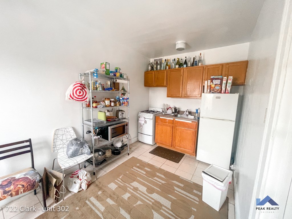 a small kitchen with white appliances and wooden cabinets