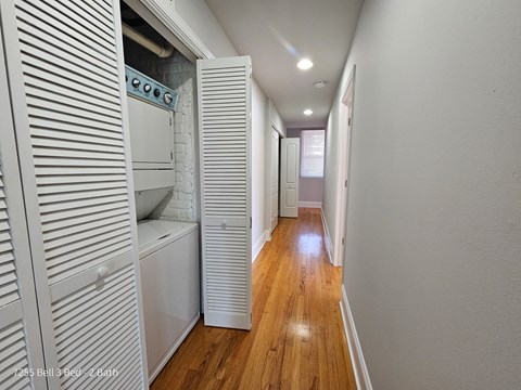 a laundry room with a washer and dryer and a hall to a bathroom