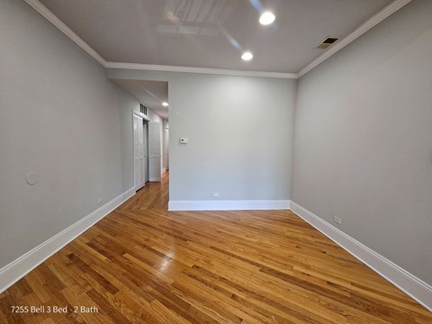 a living room with a hard wood floor and grey walls