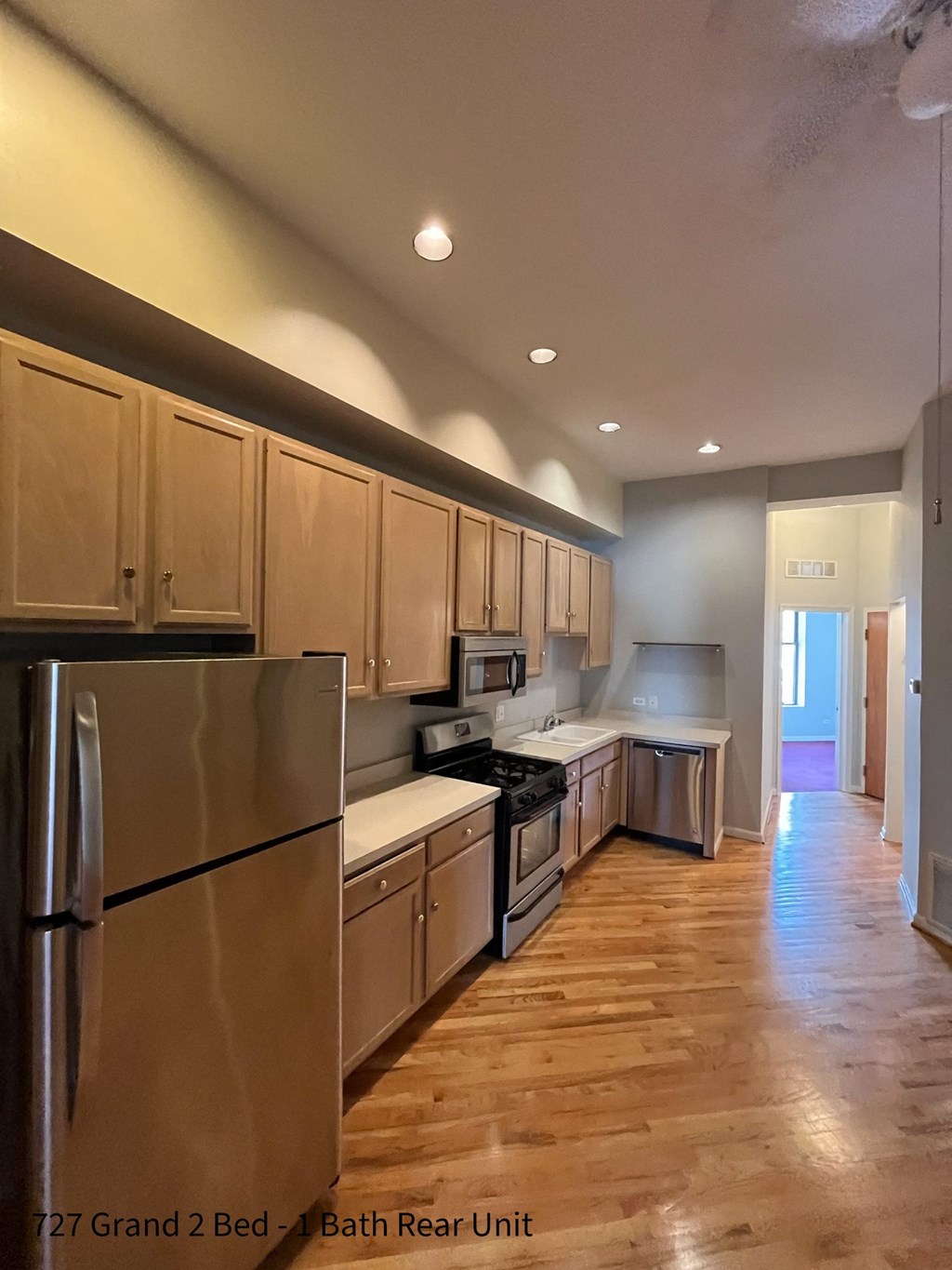 a kitchen with wood floors and wooden cabinets