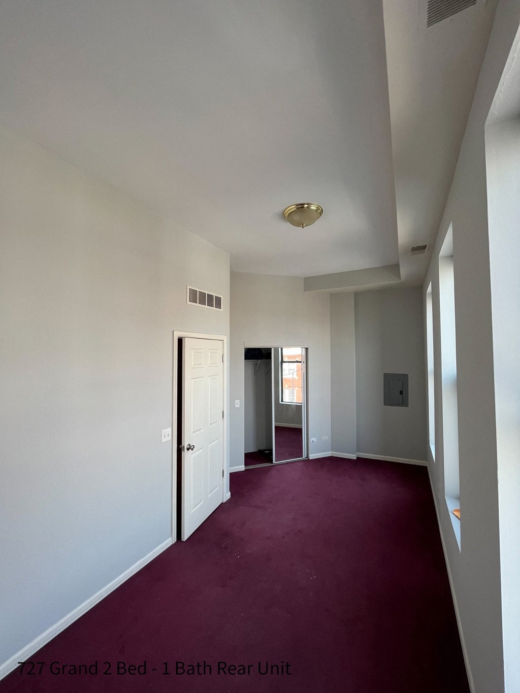 a view down a hallway with a red carpet and a white door