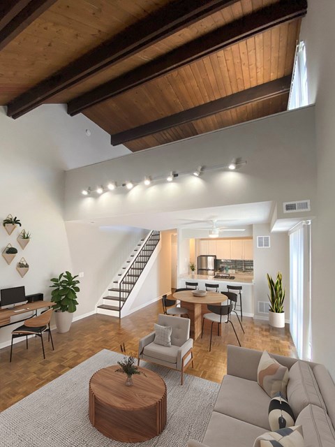 A living room with a couch, a coffee table, and a staircase.