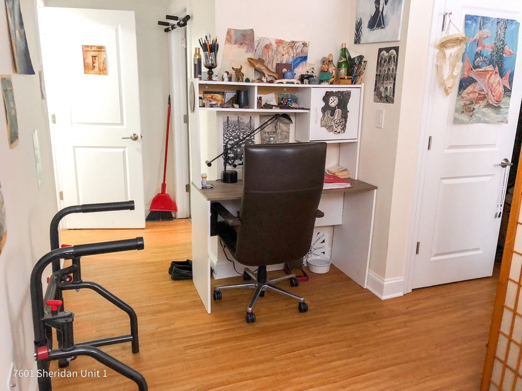 a desk with a chair in a room with a wood floor
