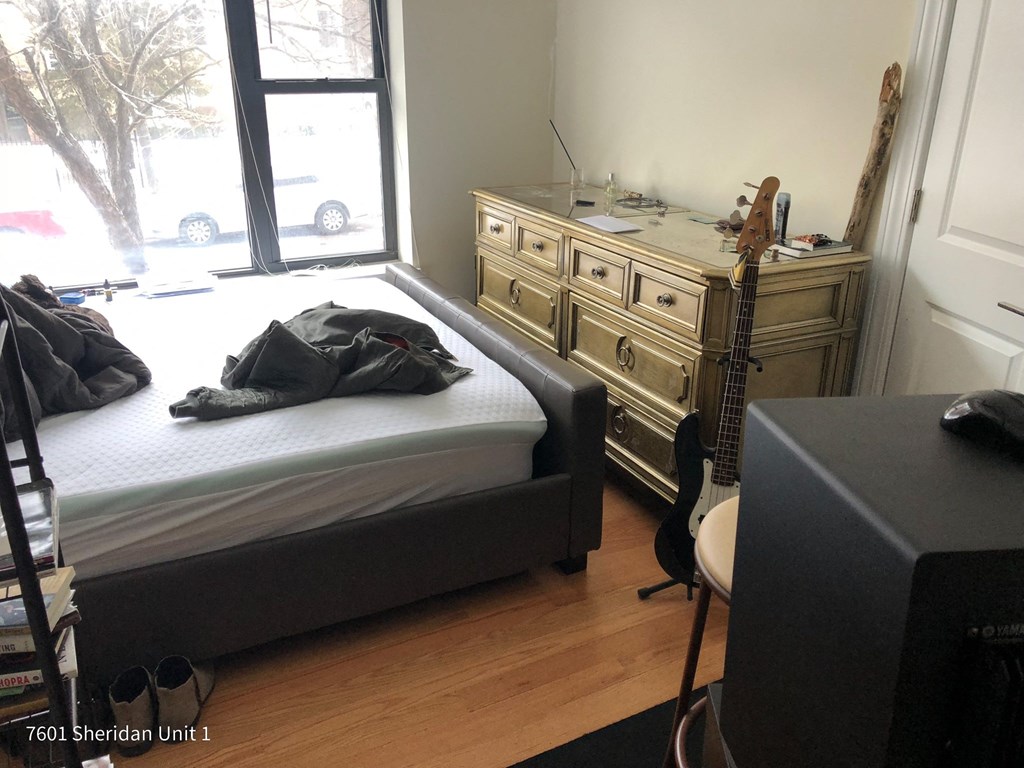 a bedroom with a bed and a guitar in it