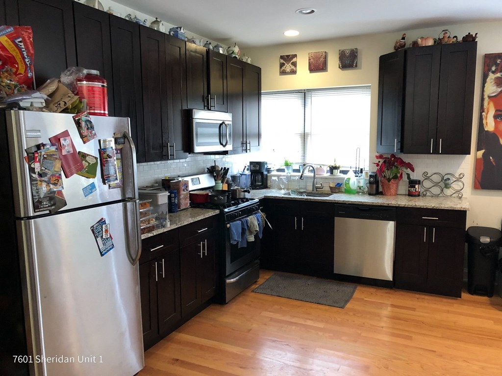 a kitchen with black cabinets and a refrigerator