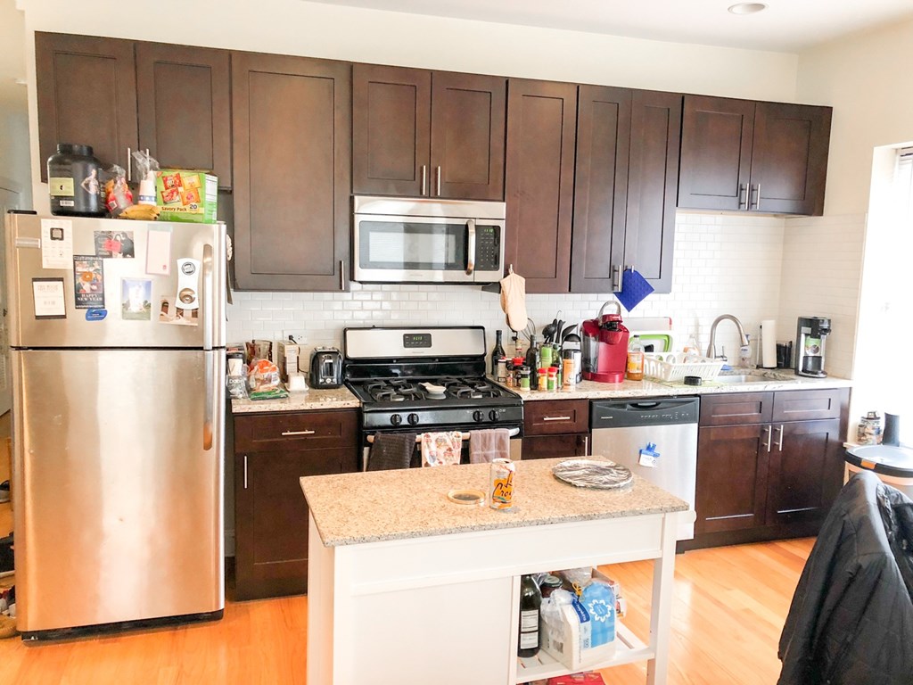 a kitchen with wooden cabinets and stainless steel appliances