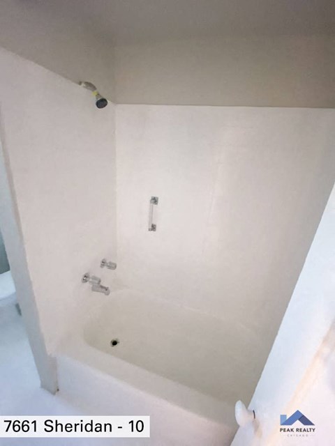 a white bathroom with a shower and a sink