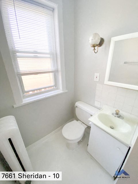 a bathroom with a toilet and a sink and a window