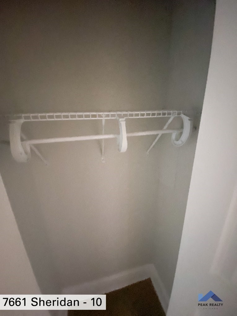 a walk in closet with a white closet rack