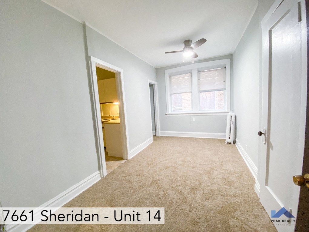 an empty room with a ceiling fan and a window
