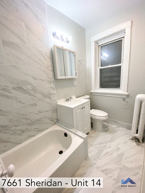 a bathroom with a tub and a sink and a window
