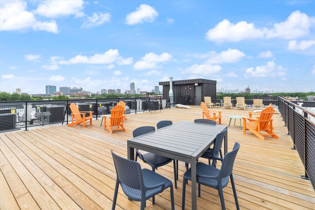 the deck on the top of the building has tables and chairs on it