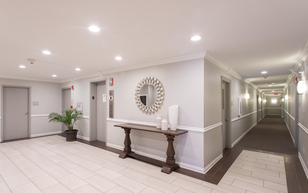 a hallway with a table and a mirror on the wall