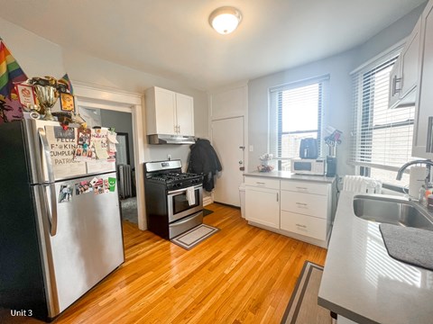 A kitchen with a refrigerator covered in magnets and notes.
