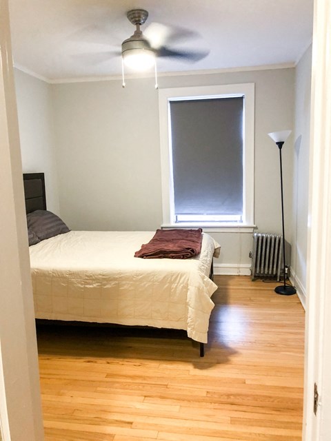 a bedroom with a bed and a window and a ceiling fan