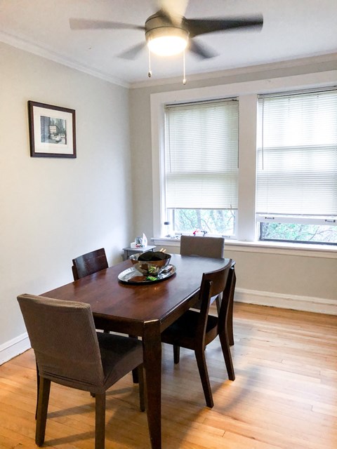 a dining room with a table and chairs and a ceiling fan