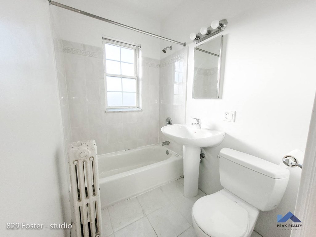 a white bathroom with a sink toilet and bath tub