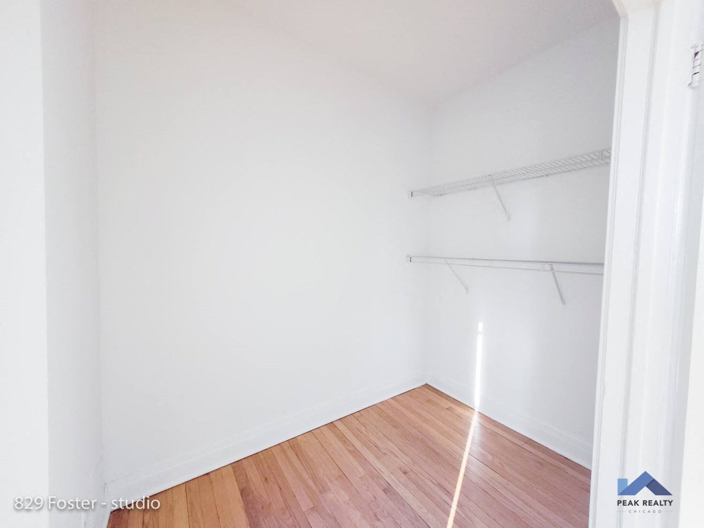 a empty room with white walls and a wood floor