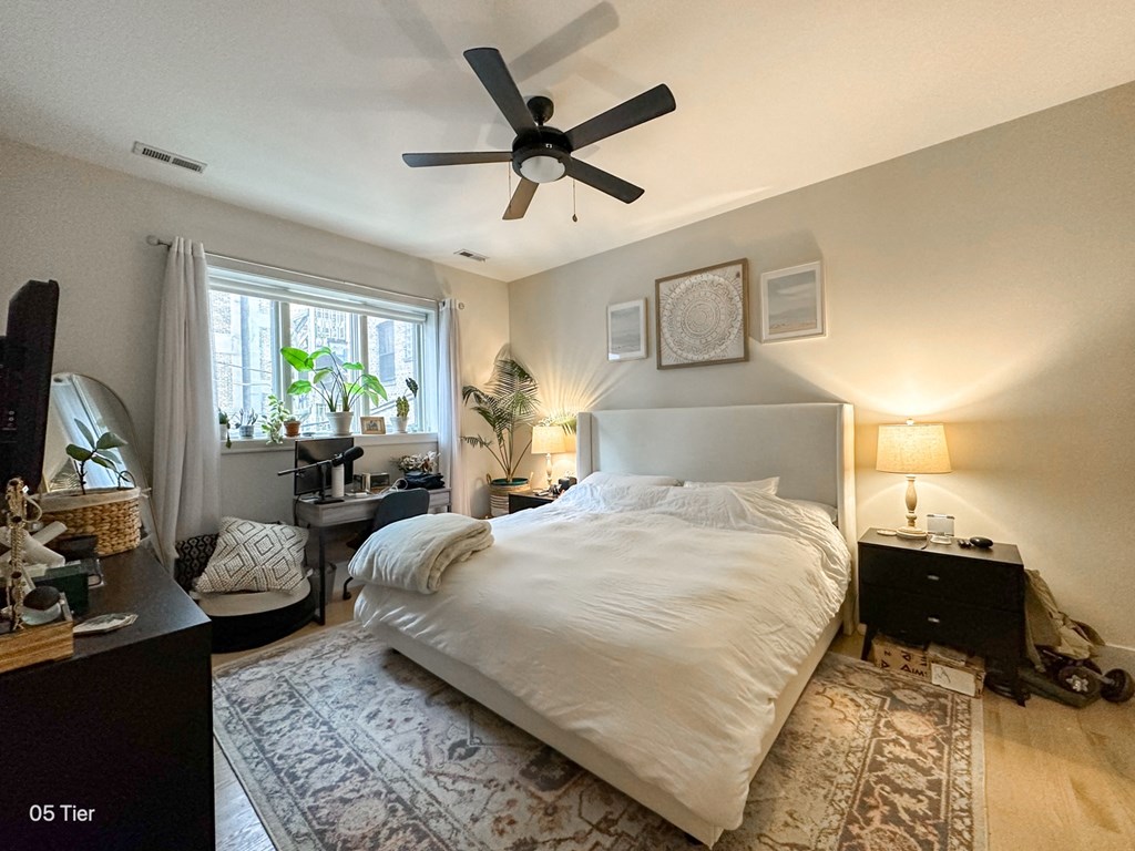 a bedroom with a large bed and a ceiling fan