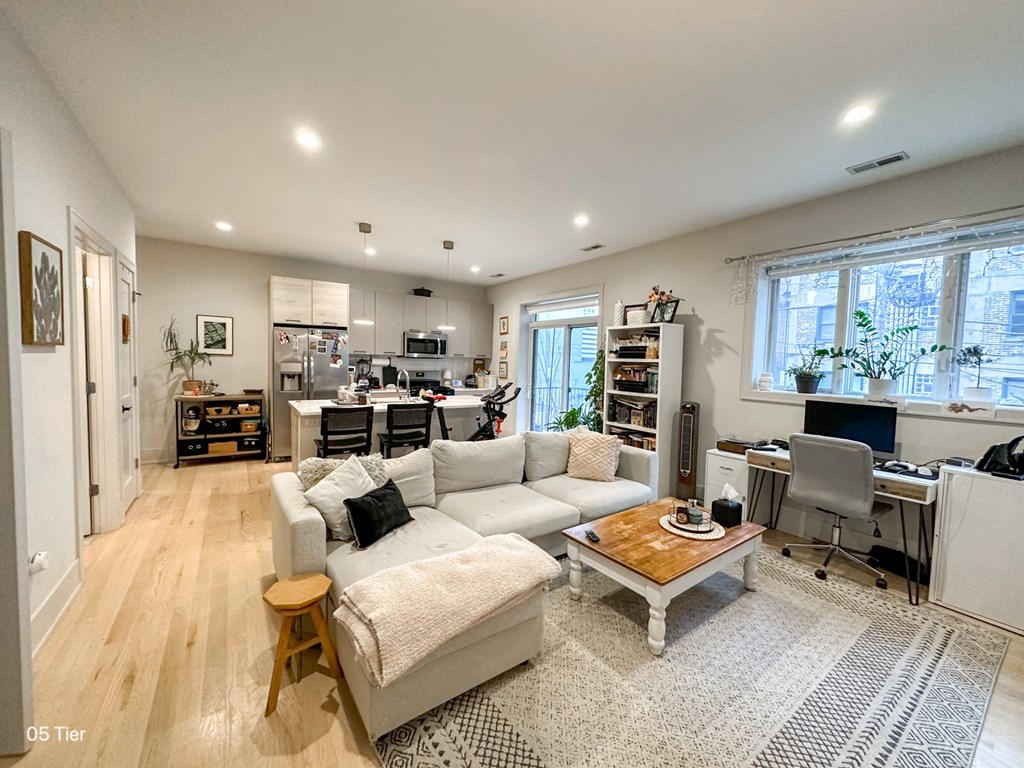 a living room with a couch and a table in front of a kitchen