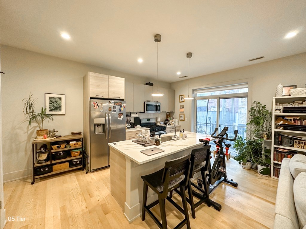 a kitchen with a large island with chairs and a counter top