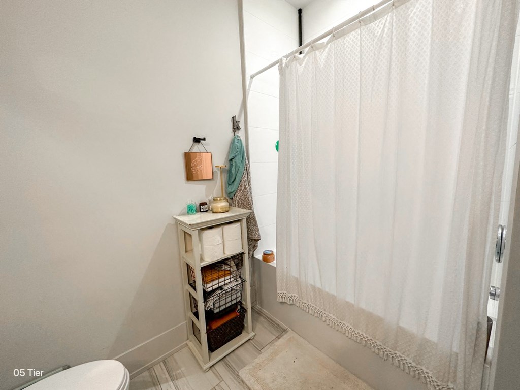 a small bathroom with a shower and a white shower curtain