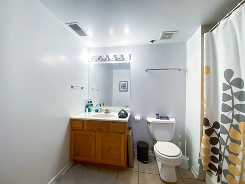 A bathroom with a toilet, sink, and shower.