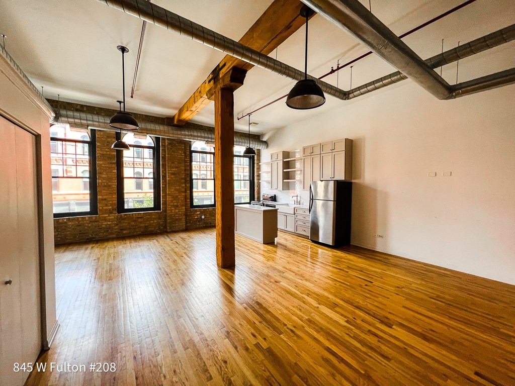 A large empty room with wooden floors and exposed ceiling beams.