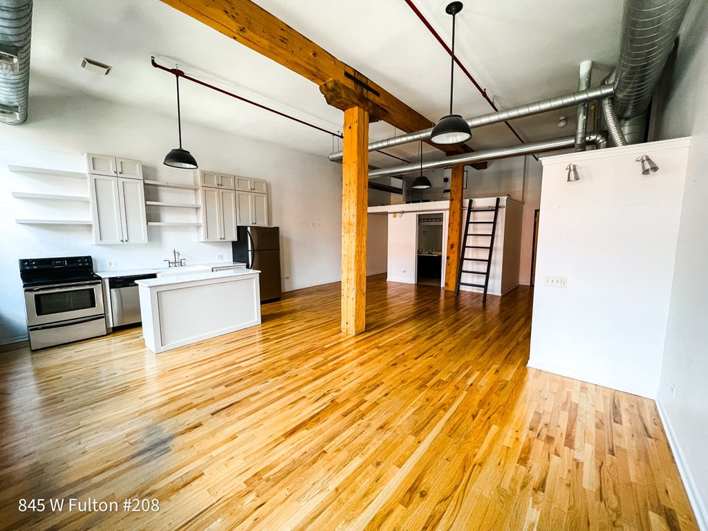 A kitchen with wooden floors and white walls.