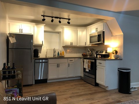 A kitchen with a refrigerator, microwave, and oven.