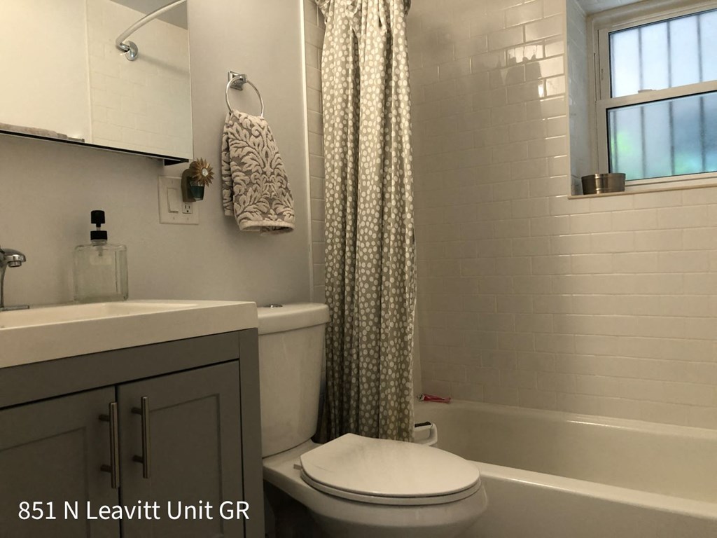 a bathroom with a toilet sink and shower and a shower curtain