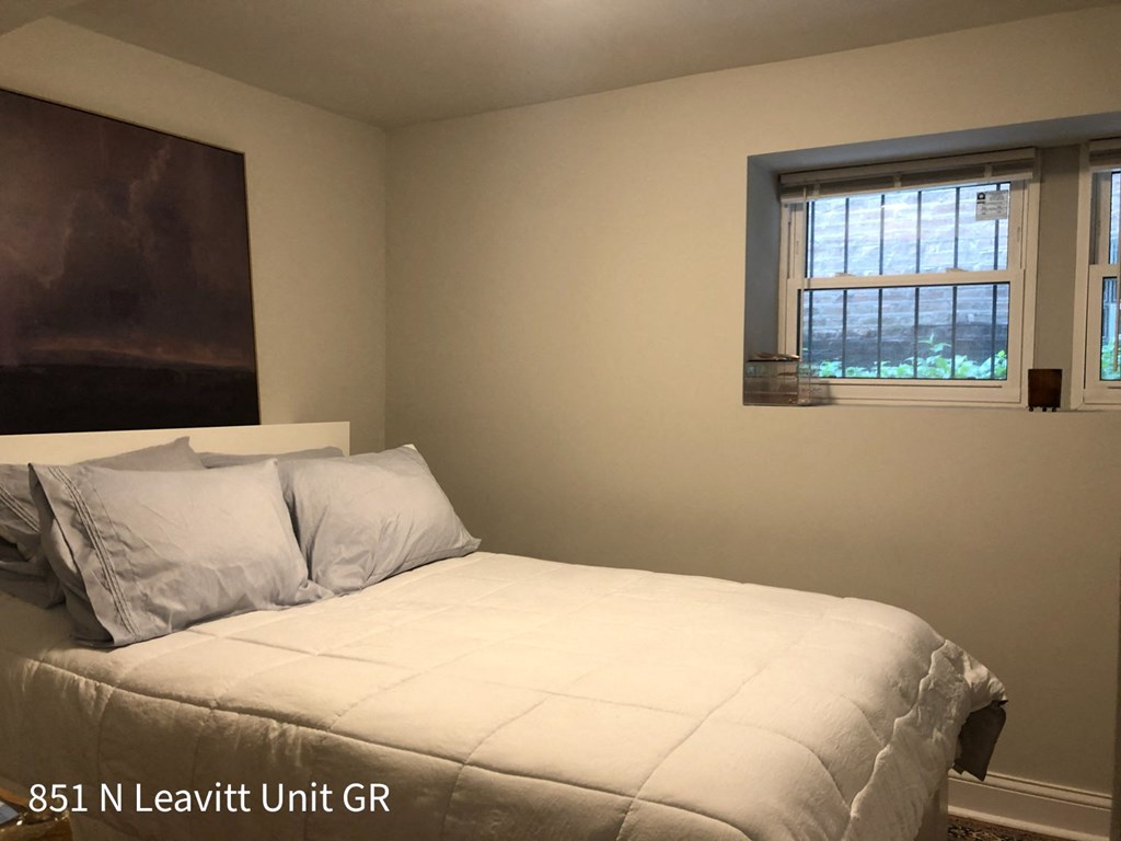 a bedroom with a white bed and a window