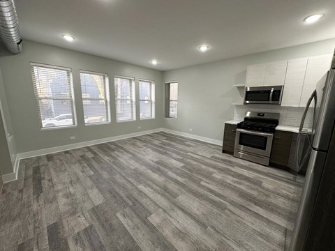 A spacious kitchen with a grey floor and stainless steel appliances.