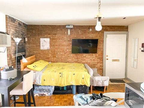 a bedroom with a bed and a dining room with a table and chairs