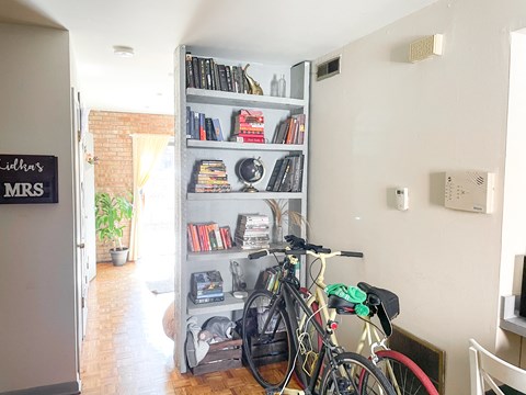 two bikes parked in front of a bookshelf in a living room