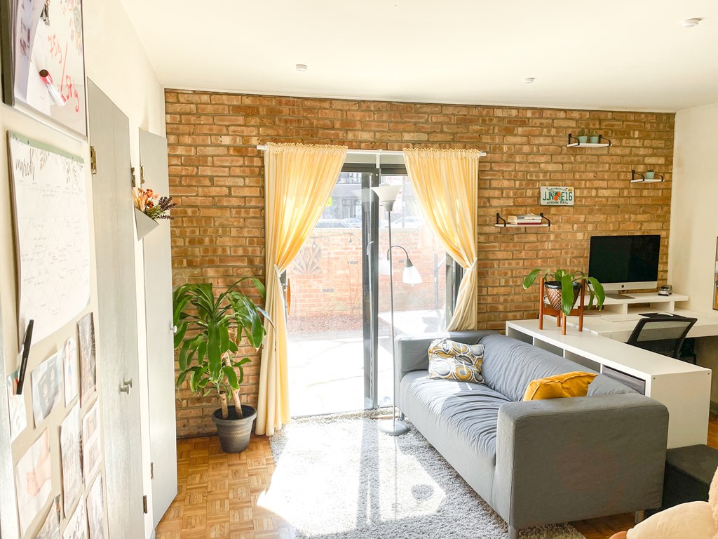 a living room with a couch and a brick wall