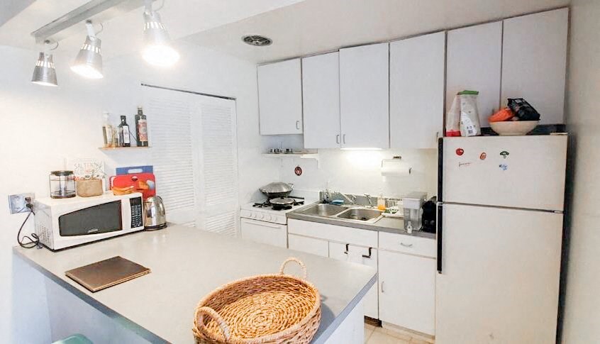 a white kitchen with a microwave and a refrigerator