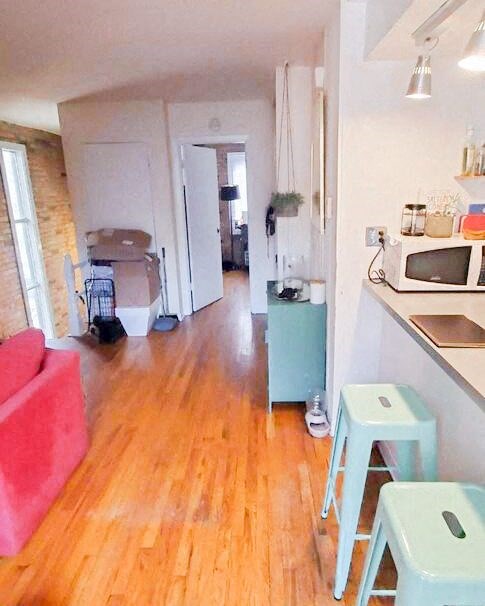 a living room and kitchen with a wood floor