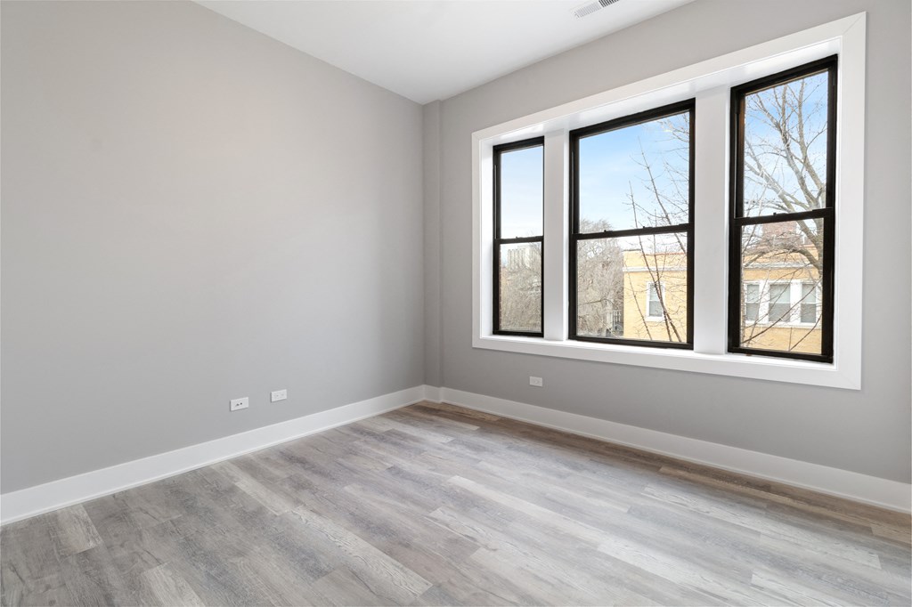 an empty room with wood floors and a window