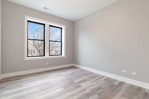 an empty room with wood floors and a window