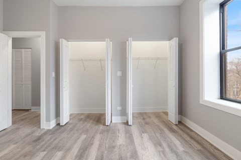 an empty room with three closet doors and a wood floor