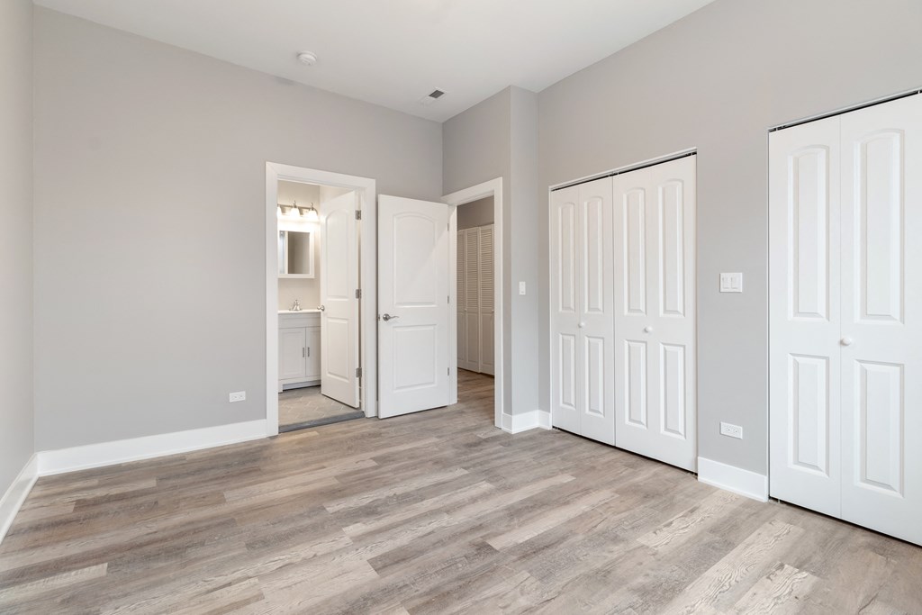 a bedroom with two closets and a door to a bathroom