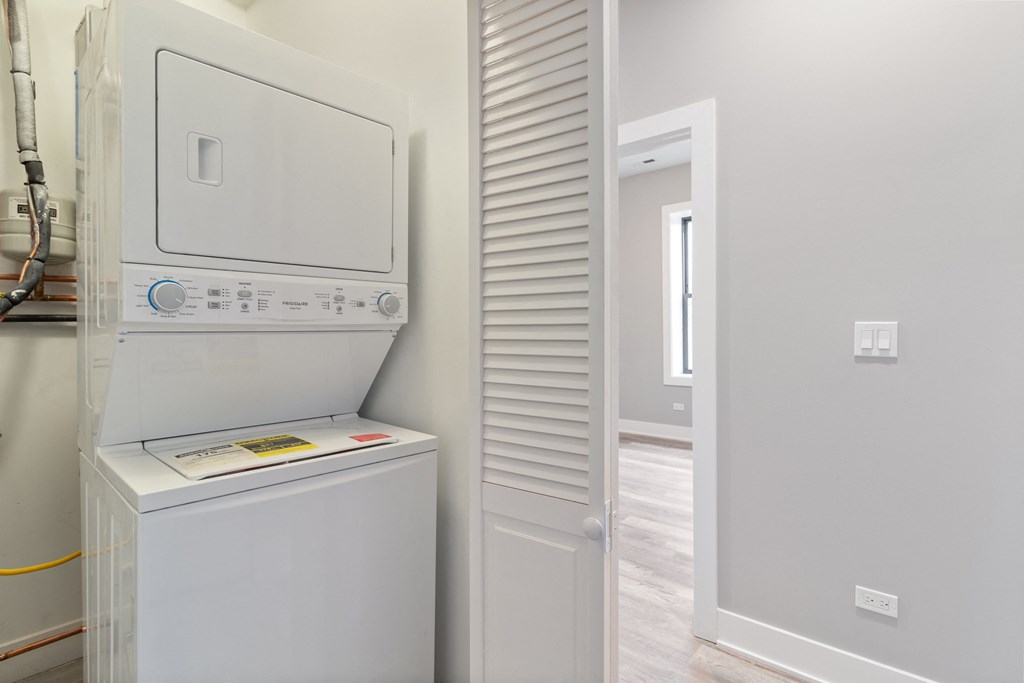 a laundry room with a washer and dryer and a door to a bathroom